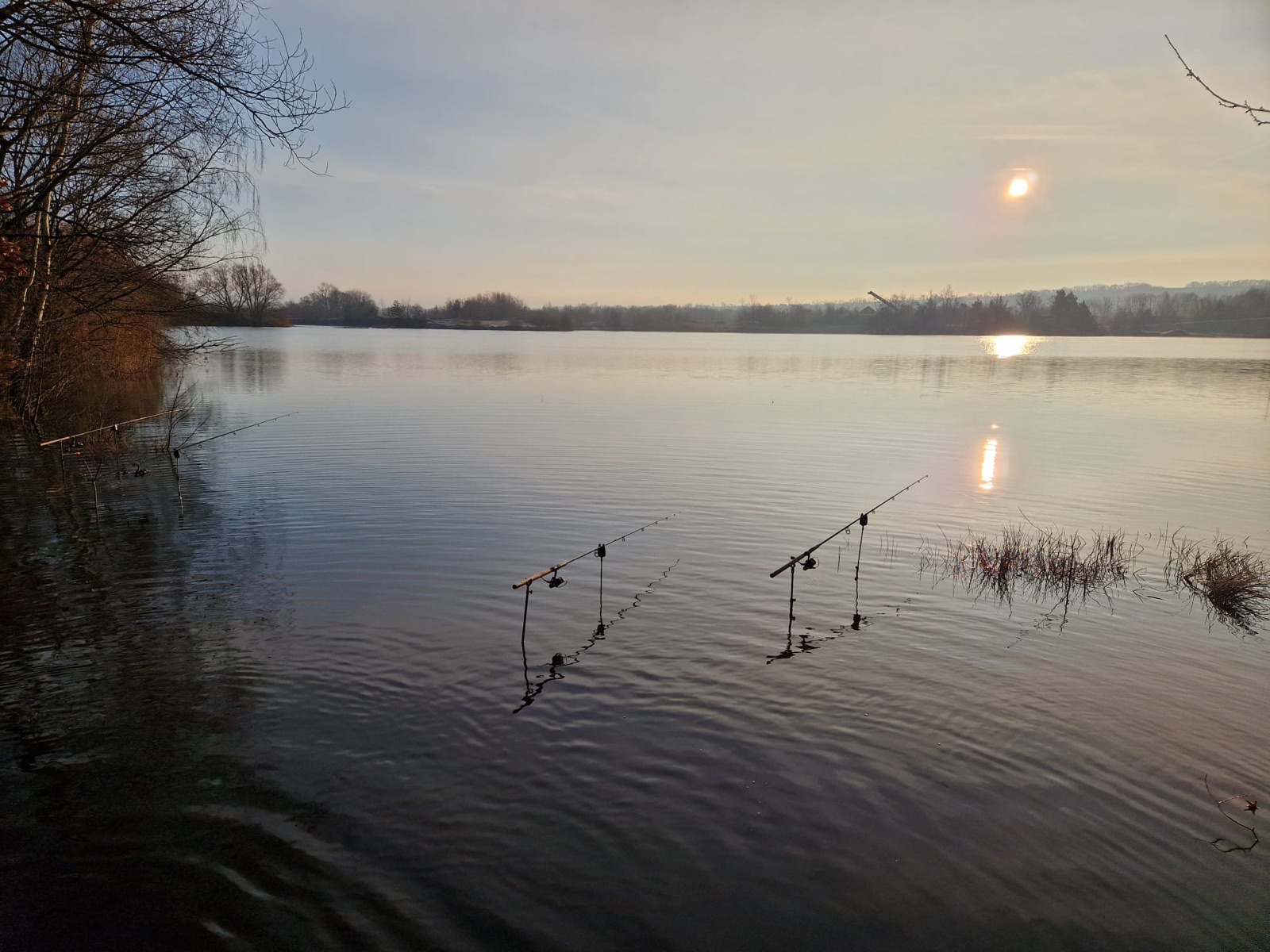 Zwei einzeln positionierte Banksticks stehen im See, Abendlicht